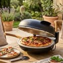 The DMD Collective electric pizza oven includes a stone baking plate and accommodates pizzas measuring up to 12 inches