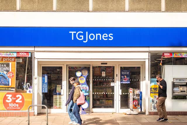 Members of the public walking past the exterior of a TG Jones shop on a high street