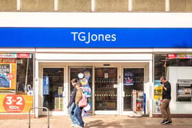 Members of the public walking past the exterior of a TG Jones shop on a high street