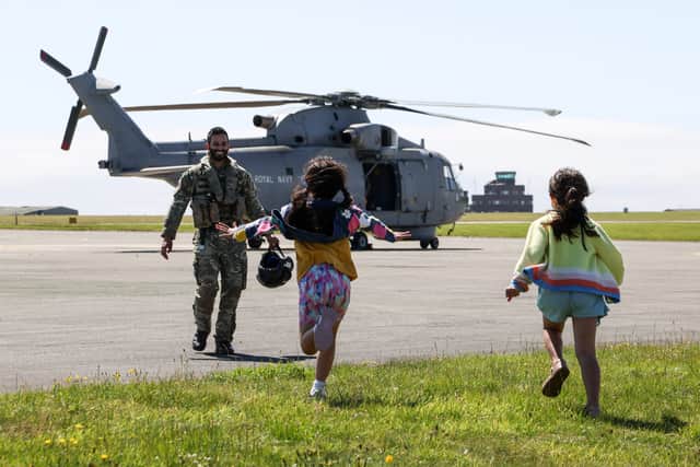 A pilot from 820 NAS greets his daughters.820 Naval Air Squadron return home from Cyprus to family at Royal Naval Air Station (RNAS) Culdrose