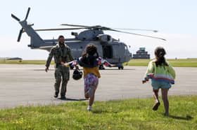 A pilot from 820 NAS greets his daughters.820 Naval Air Squadron return home from Cyprus to family at Royal Naval Air Station (RNAS) Culdrose