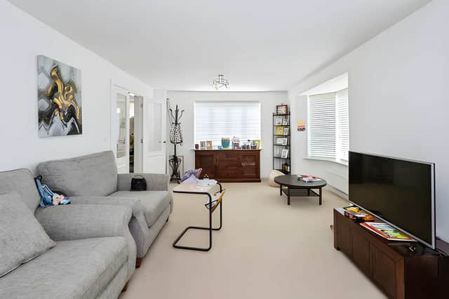 A bright bay-windowed living room provides a comfortable setting for relaxing or entertaining