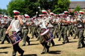 Beating Retreat rehearsals at HMS Excellent on Whale Island, with Royal Marines Band Service musicians parading through the grounds amid the hot temperatures.