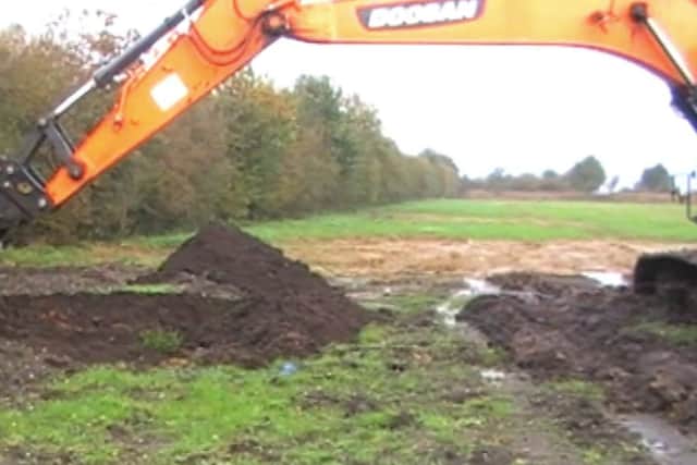 The digger digging a hole for the waste