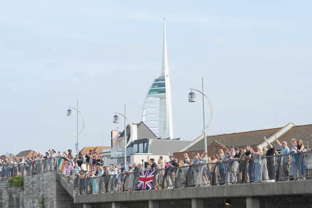 Spectators lining the Hot Walls waiting to see the Royal Navy flagship.