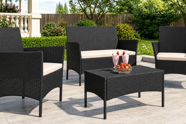 The four-seater rattan garden furniture set includes a sofa, two armchairs and a matching table