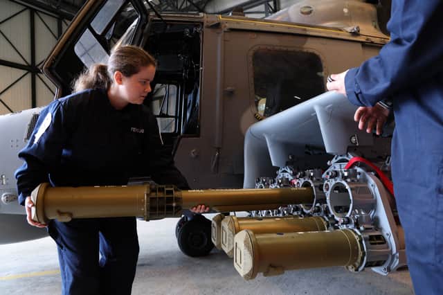 Handlers equipping a Martlet missile onto a Wildcat helicopter.