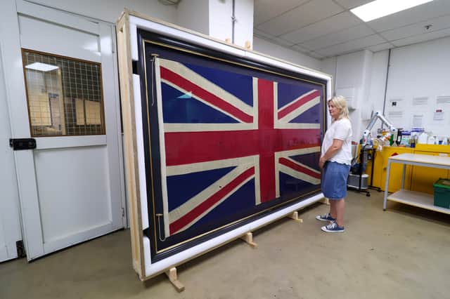 Rachael Metcalfe, Conservation Officer at North East Museums, looking at the flag.