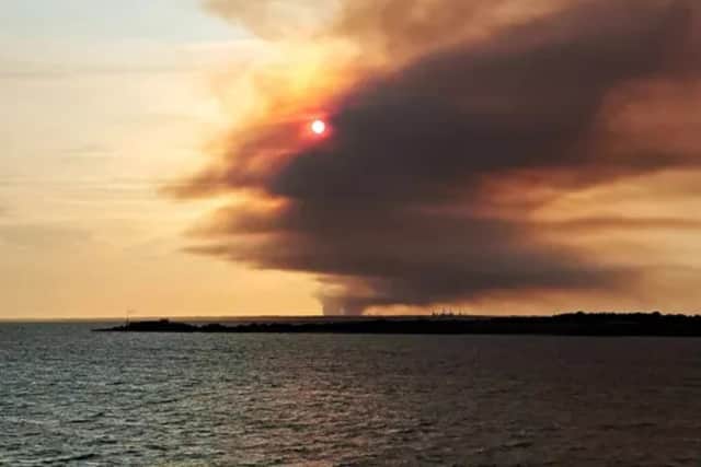 HGV fire smoke from the A31 as seen from a Wightlink ferry off the coast of the Isle of Wight.