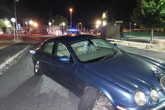 A Jaguar S-Type has smashed into a traffic island after driving the wrong way around a roundabout following a police attempt to pull the driver over.