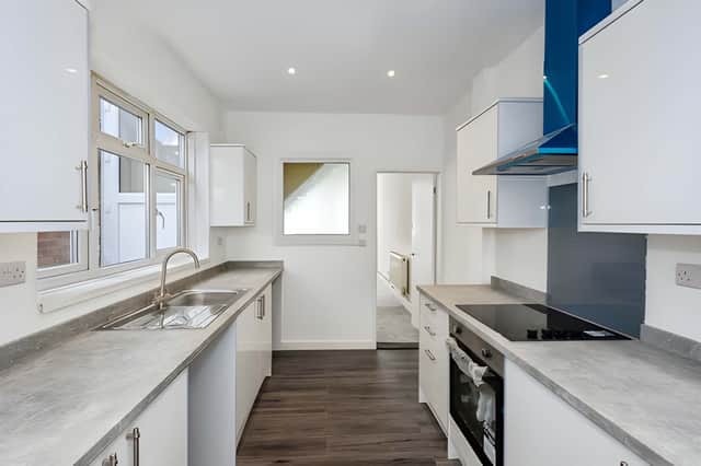 A newly fitted kitchen provides a clean, modern space with a built-in oven, hob and extractor.
