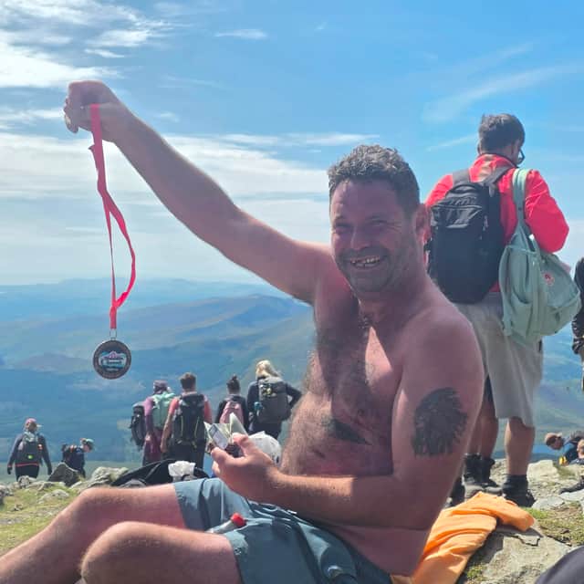 Danny with his summit medal at the top of Snowdon