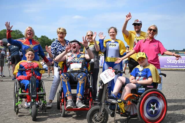 Andy Read, front middle, leads the cheers at the finish line with TV star Clare Balding, back row, second-left.
