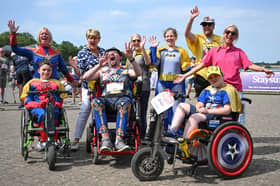 Andy Read, front middle, leads the cheers at the finish line with TV star Clare Balding, back row, second-left.