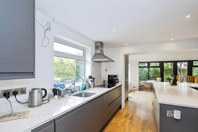A central island anchors the modern kitchen, which forms part of an open-plan living and entertaining space