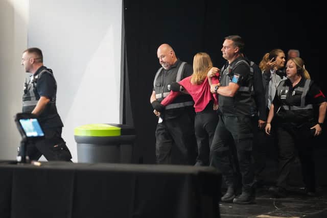 A protester is removed during Nigel Farage's speech at the Reform UK National Conference, at the National Exhibition Centre in Birmingham.