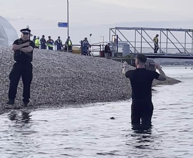 Screen grab taken from video dated 06/09/26 of a man believed to be Daniel Thomas, known as Danny Tommo, standing in the water livestreaming the operation to rescue around 120 migrants who were brought into the harbour at Portsmouth in Hampshire. Masked demonstrators blocked the road leading away from the RNLI Portsmouth Lifeboat Station at Eastney Marina. Issue date: Monday September 7, 2026. PA Photo. Photo credit should read: Barry Williams/PA Wire