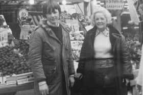 Gary, aged 13, with his grandmother at their family's fruit and veg stall 