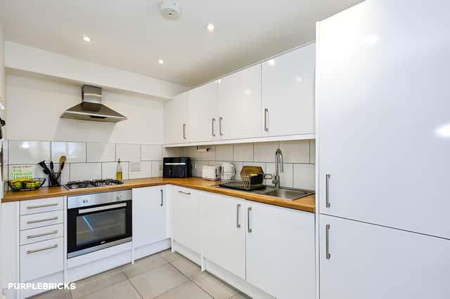 The contemporary fitted kitchen includes a range of built-in appliances within the apartment's open-plan living space