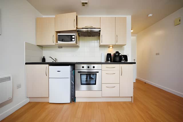 The contemporary kitchen area is neatly incorporated into the studio, with built-in cooking appliances and space for dining