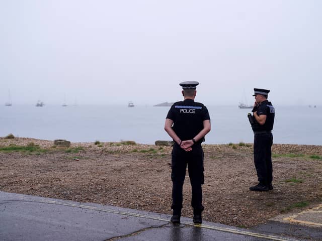 Police officers at Eastney Point, near Eastney Beach, Portsmouth, following a protest after people thought to be migrants were brought into the harbour (PA)