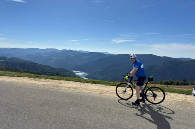 Sean Scott on his bike with a scenic Swiss landscape behind him.