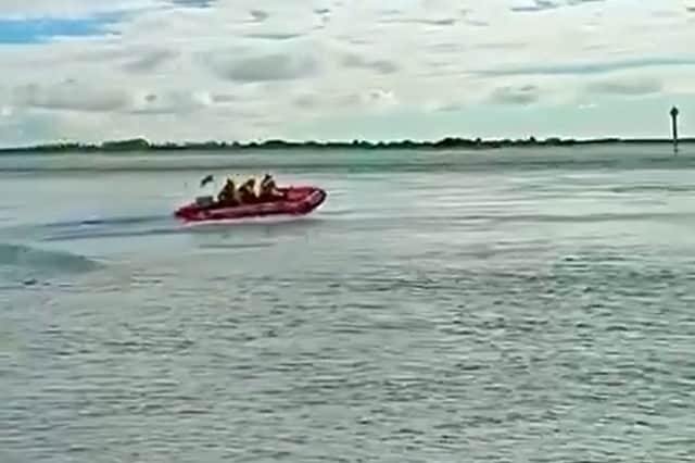 RNLI lifeboat crew from Hayling Island racing off to rescue a fisherman who was swept into the water.