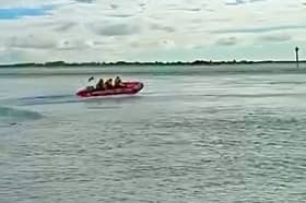 RNLI lifeboat crew from Hayling Island racing off to rescue a fisherman who was swept into the water.