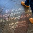 The quotes were made using reverse graffiti, and appear on pavements across London
