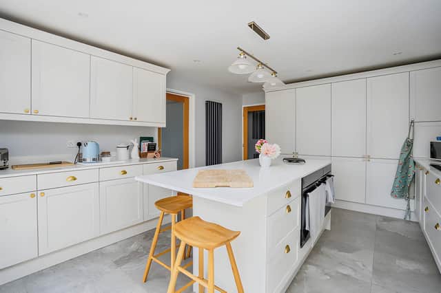 A newly renovated kitchen with integrated appliances and two electric ovens provides a contemporary setting for cooking and everyday family life