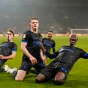 Goalscorer Terry Devlin, centre, with Eoin Kenny, Odin Bailey and Jojo Dia celebrate Pompey's equaliser at Wolves in front of the away end at Molineux.