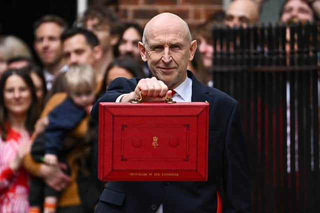 Former defence secretary John Healey holding up the traditional red ministerial box as he leaves 11 Downing Street, London, before delivering his first Budget to the Houses of Parliament.