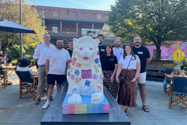 Hampshire Flag Company’s Commercial Director Rod Sessions with Portsmouth Pride Trustees CP Robinson and Jo Taffurelli alongside the ‘One Hundred Voices: A Portsmouth Patchwork’ lion.