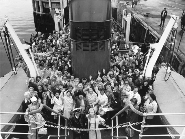 Happy smiles and waves from Women's Circle members on the ferry as they leave Gourock for the trip across to Dunoon. Pictured (centre foreground) is Orrall Hewison with Captain Duncan Munro of the Maid of Cumbrae ferry.