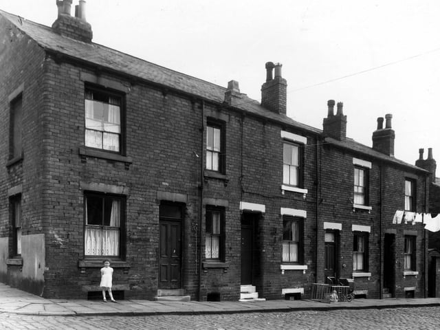 Four houses on Leith Street, seen from the intersection with Fertile Street in May 1960. A little girl is standing outside number 22 on the left, 20 is on the right. Next, 18 has a pram outside, also a toddler sat in a wooden playpen.