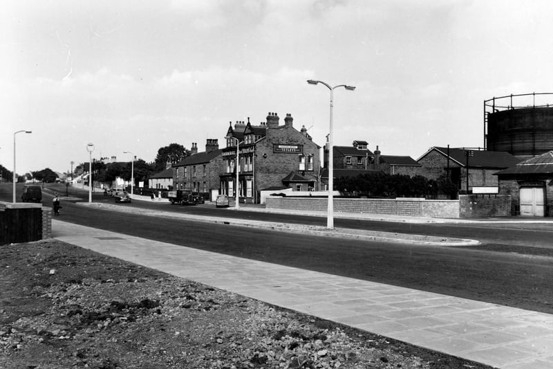 A completed Cross Gates Bridge in September 1955. Station Hotel, a Tetleys public house is visible on the right. On the extreme right is a gasometer for storing the community's gas.