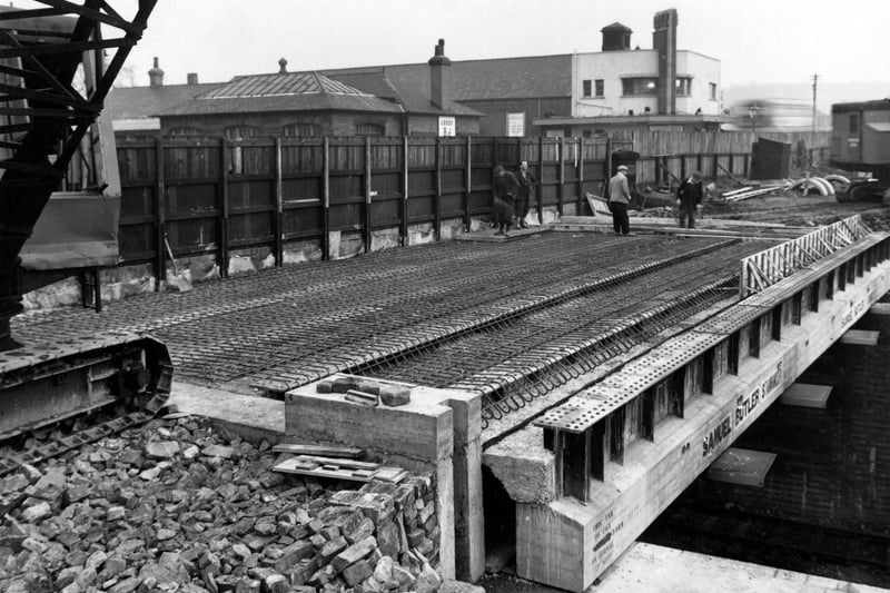 Construction work on Cross Gates Bridge at Station Road in October 1954. Cranes and workmen can be seen. Cross Gates Station and the Ritz cinema are visible behind a wooden fence.