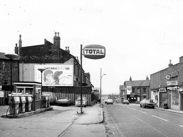 Domestic Street towards the railway viaduct in the distance. On the left is the forecourt of a petrol filling station. The next building along, William Hill bookmakers.
