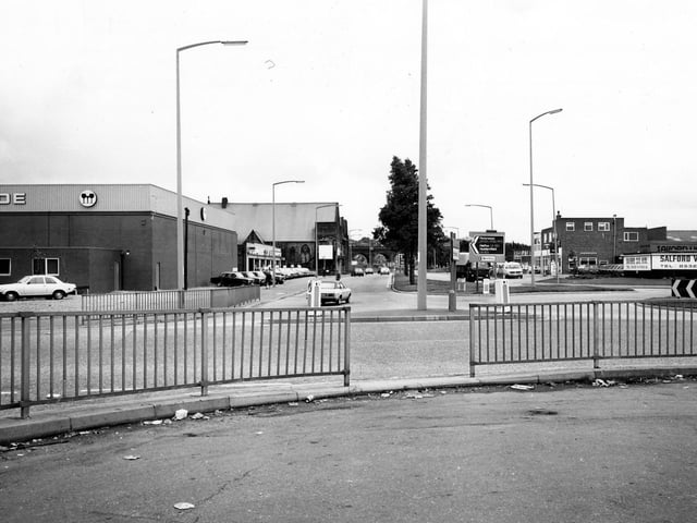 A roundabout on Domestic Street, looking south-east towards the railway viaduct, the arches of which can be seen in the distance. On the left is the junction with Holbeck Lane, with Melcade Ltd, Wine and Spirit Merchants on the corner. On the right is Salford Van Hire Ltd.