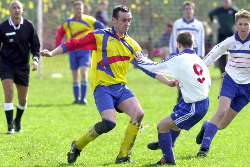 Mark Duffy of Holbeck passes the ball past Jamie Marshall and Mark Frost of Rothwell in the Leeds Combination League in March 2000.