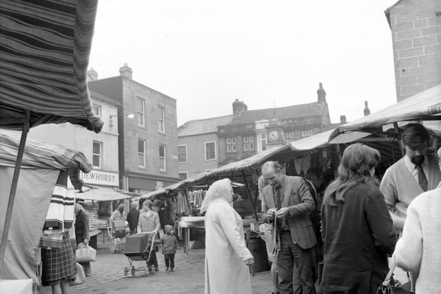 Otley Market showing traders and customers on a busy morning in September 1974. The clock tower can be seen in the background. This photograph was originally taken for Leeds City News