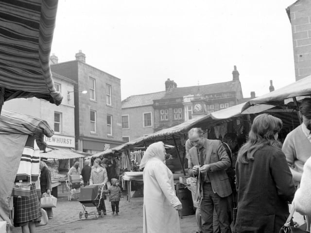 Otley Market showing traders and customers on a busy morning in September 1974. The clock tower can be seen in the background. This photograph was originally taken for Leeds City News.