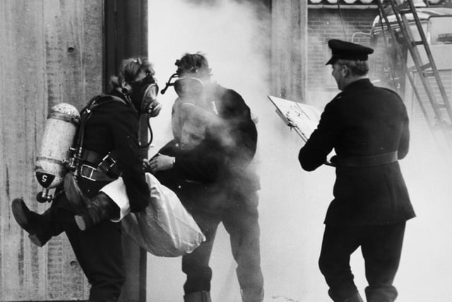 It looks dramatic but the fireman 'overcome' by smoke and his rescuers (wearing breathing apparatus) were taking part in one of the last drills of the Leeds Fire Brigade before it merged into the West Yorkshire Metropolitan County Fire Brigade