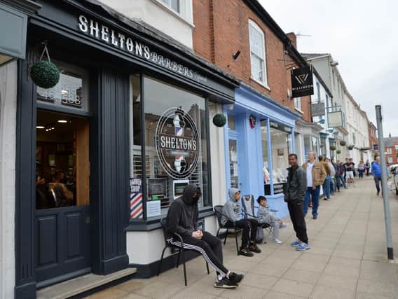 Busy scenes outside Shelton's barbers on the High Street.