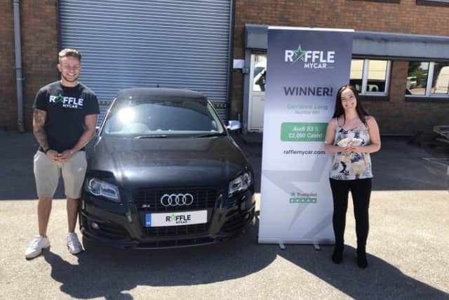 Audi car and 2,000 cash prize winner Carrianne Long from Lincoln with Joey Doyle of RaffleMyCar