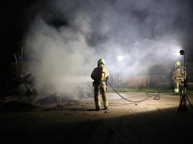 Firefighters wearing breathing apparatus used two high pressure hose reels to bring the building fire under control.
