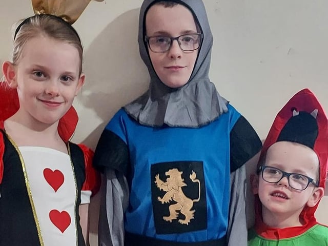 Queen of Hearts Hannah-Louise, seven; knight John Paul, 10; and Kristian-Lee, four, a friendly dragon