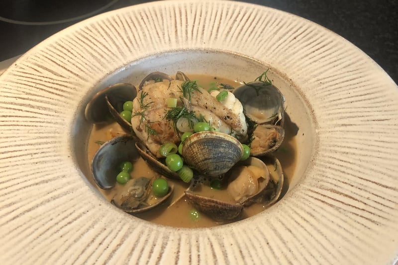 Monkfish and clams with fresh peas in a rich stock