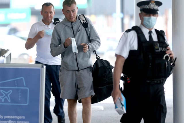 PACEMAKER, BELFAST, 15/6/2020: A police officer with passengers as they arrive at Belfast International airport this morning for the first domestic flight to leave the airport since it was shut down after Coronavirus restrictions were put in place
