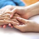 A generic photo of a woman holding a dementia sufferer's hands.